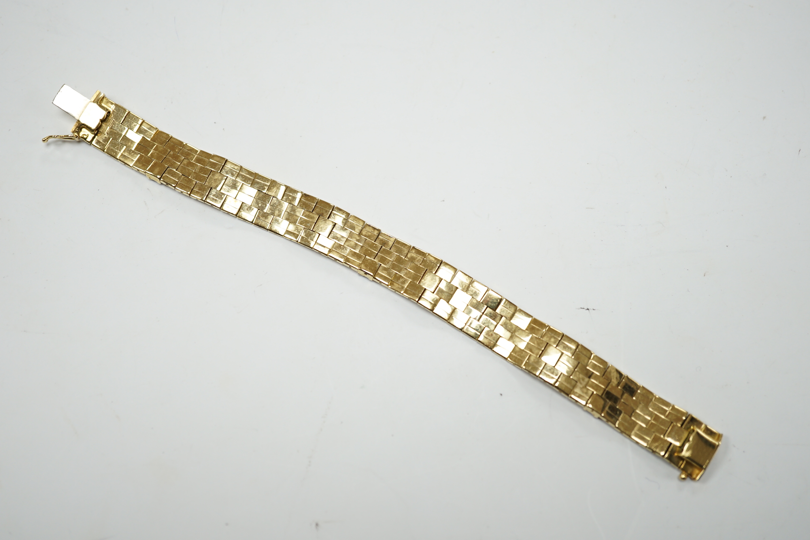 A textured yellow metal and eleven stone square cut ruby set bracelet, 16.5cm, gross weight 36.8 grams.
